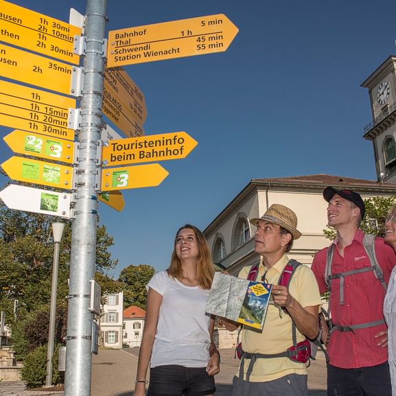 Gruppe Wanderer studieren die Wegweiser verschiedener Wanderrouten