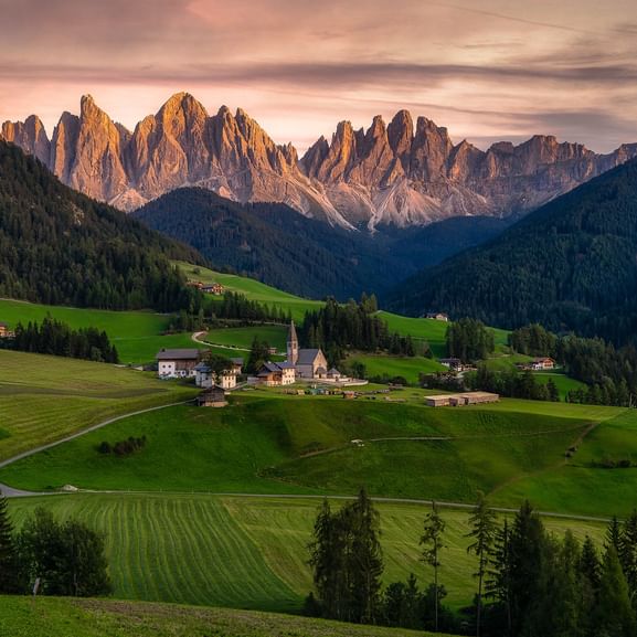 Landschaft in Südtirol mit Dolomitengipfeln im Hintergrund.