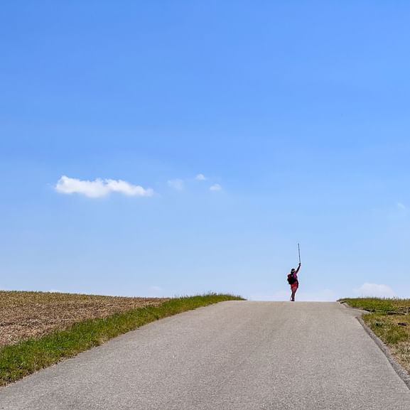Wanderer auf einer Anhöhe mit weitem Himmel
