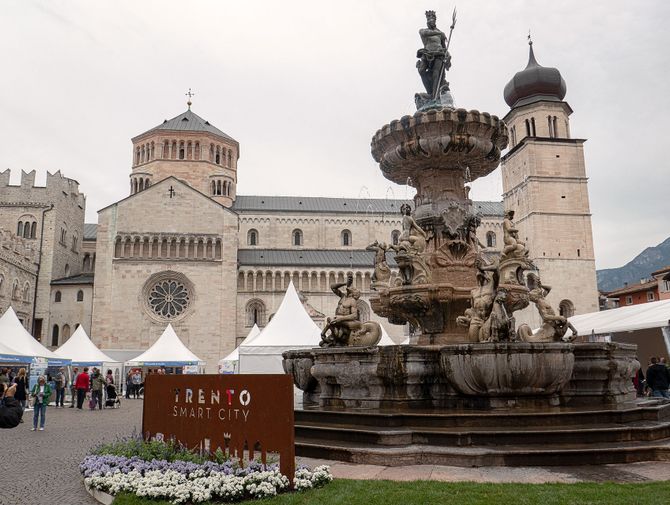Der Neptunbrunnen in Trient steht auf einer Plaza mit der Kathedrale von Trient im Hintergrund.
