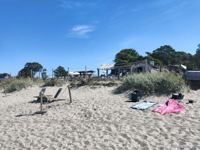 Zwei Badetücher liegen auf weissem Sand am Strand von Tofta. 