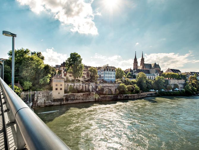 Photo von einer Brücke aus auf das Ufer des Rheins mit Kirche im Hintergrund
