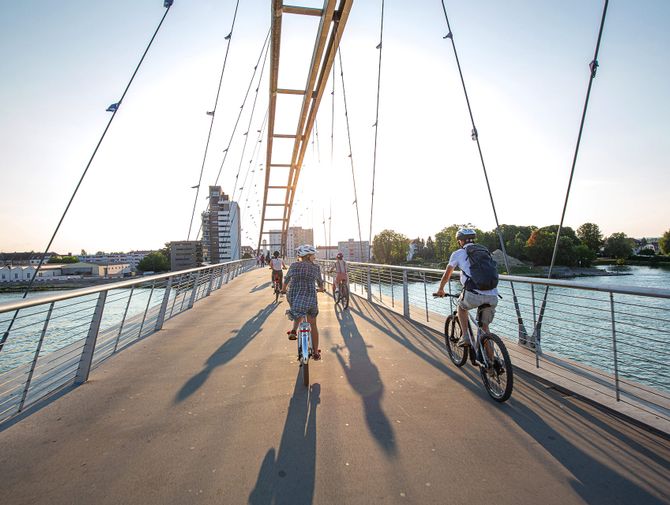 Des cyclistes passent sur un pont cycliste dans la ville de Bâle 