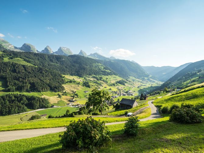 Blick auf ein Dorf im Tal auf dem Alpenpanorama Weg