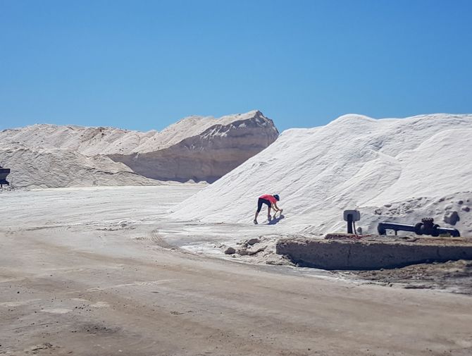 Ein Velofahrer ist bei einem Salzhaufen damit beschäftigt, etwas mitzunehmen.