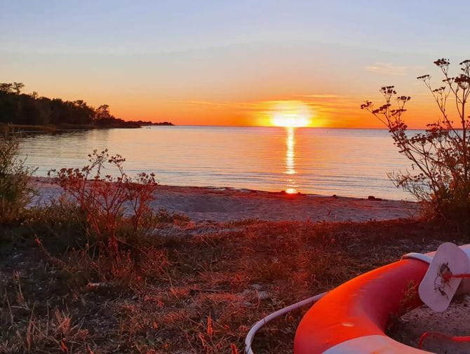 Ein orange roter Sonnenuntergang am Meer in Burgsvik auf Gotland. 