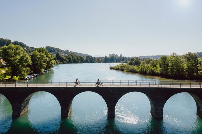 Deux cyclistes traversent l'Aar sur un pont près de Berne. 
