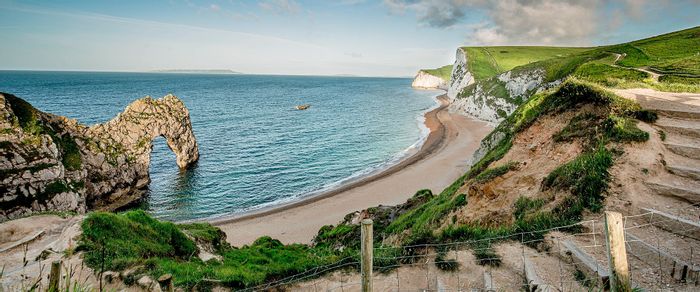 Küstenlandschaft von Cornwall mit Strand und steilen weissen Klippen.