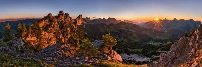 A mountain panorama at sunset. The sun is still shining slightly.
