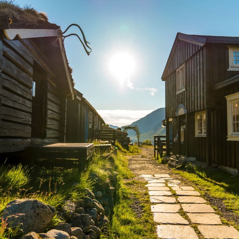 Dunkle Holzhäuser in Gjendebu in Norwegen befinden sich am Wegrand.